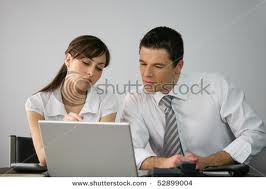 there is a man sitting in front of the computer with a woman